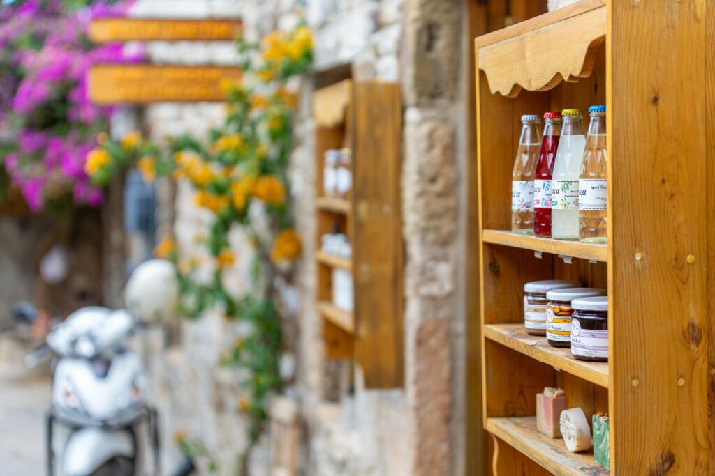 Charming street shelf with bottles and jars, next to a quaint brick alleyway.